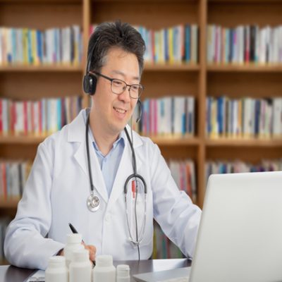 an Asian doctor who is remotely consulting with a patient. Telehealth concept