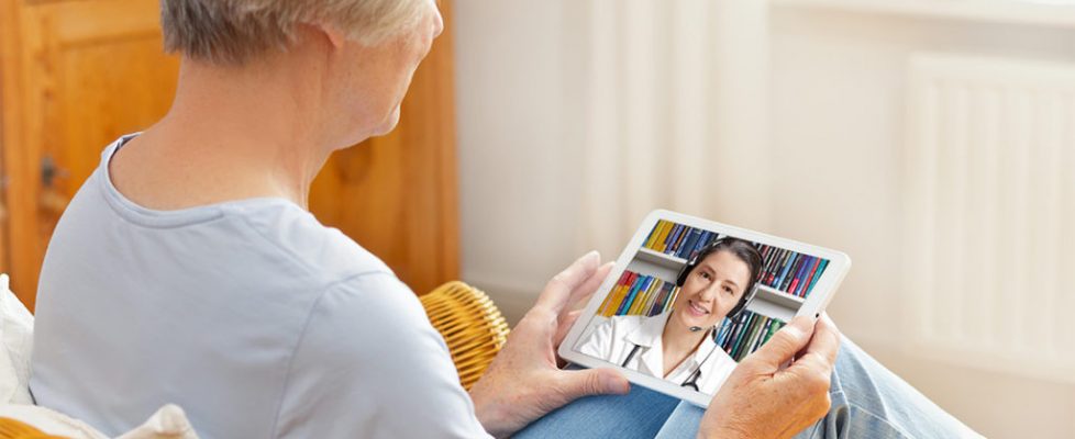 telemedicine concept, old woman with tablet pc during an online consultation with her doctor in her living room