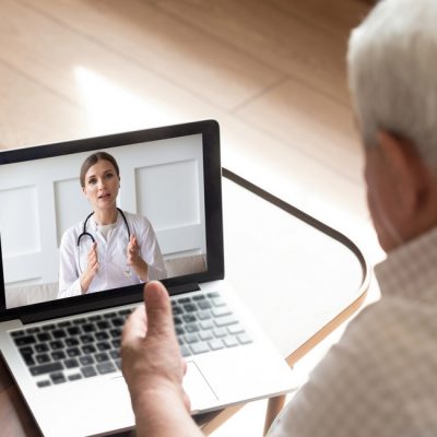 Close up older man talking with doctor online, video call
